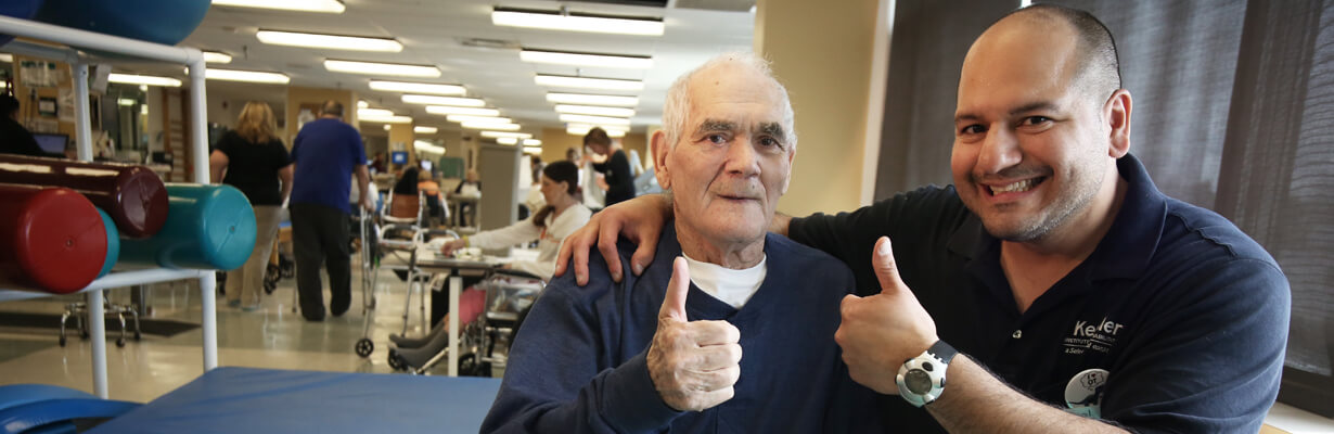 Therapist and patient giving celebratory thumbs up