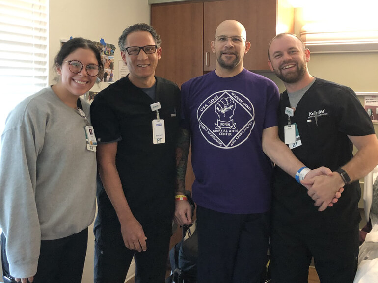Photo of Robert Del Ross with his therapists at Kessler Institute for Rehabilitation. 