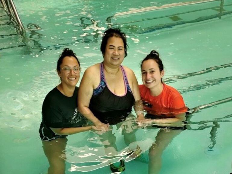 Photo of Vicky Eng in pool with her therapists.