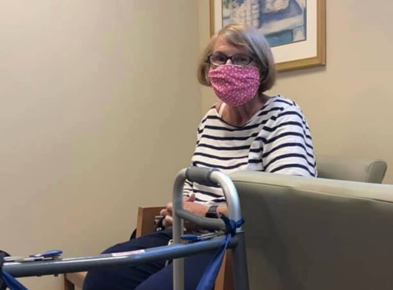 Faith sitting in a chair wearing a mask.