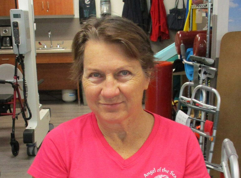 Helen smiling while sitting in the therapy gym.