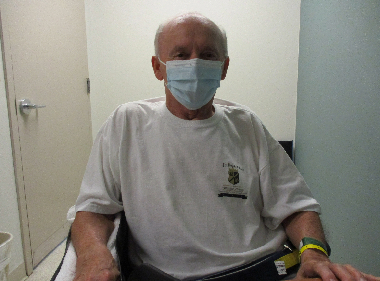 Mathias sitting in a wheelchair wearing a mask.