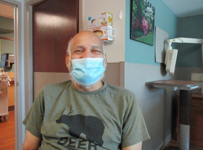 Ramon sitting in his hospital room wearing a mask.